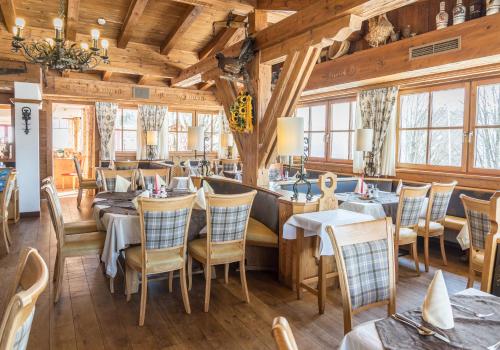a restaurant with wooden ceilings and tables and chairs at Sonnhof am Hochkönig in Mühlbach am Hochkönig
