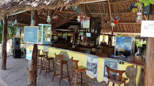 eine Bar mit Stühlen und Alkoholflaschen in der Unterkunft Makuti Villas Resort in Kilifi