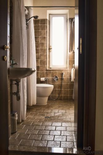 a bathroom with a sink and a toilet and a window at Los Flamingos in La Maddalena