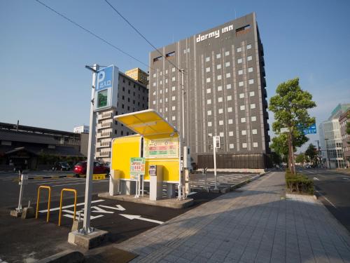 a gas station on a city street with a building at Dormy Inn Izumo in Izumo