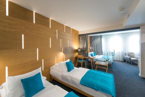 a hotel room with a bed with blue pillows at Hotel Sana in Sarajevo