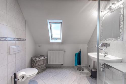 La salle de bains blanche est pourvue de toilettes et d'un lavabo. dans l'établissement Ferienwohnung Kopf, à Bad Buchau