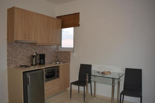 a kitchen with a table and chairs and a counter top at Thegaia Studios in Rethymno Town
