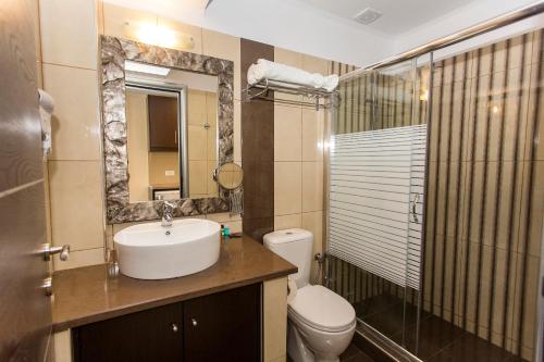 a bathroom with a sink and a toilet and a mirror at Pelagos in Parga