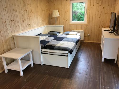 Dormitorio con cama, escritorio y TV en Penzion Nike TRIO RIVIERA en Jedovnice