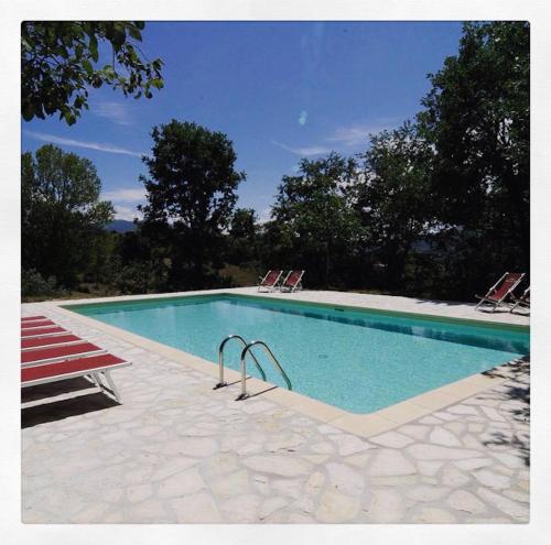 a swimming pool with two lawn chairs at Agriturismo La Corte del Lupo in Nocera Umbra