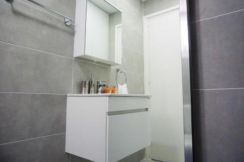 a bathroom with a white cabinet and a shower at Lazuli Sea View Beachfront Ap 43 in Larnaka