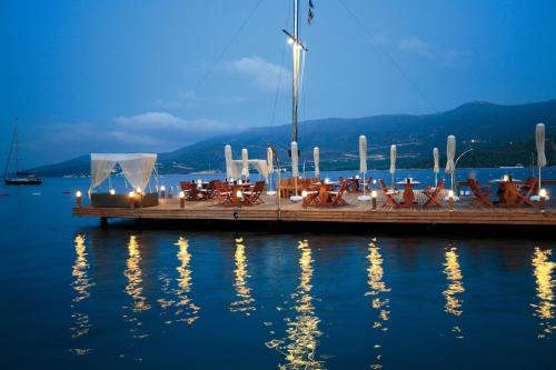 a dock with tables and chairs on the water at Torbahan Hotel in Torba
