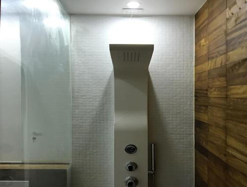 a bathroom with a shower with a light on the wall at Holiday home Isola Rossa in Isola Rossa