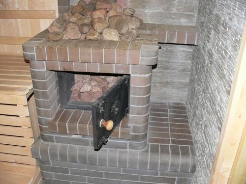 a brick fireplace with a pile of logs in it at Babite Guest House in Babīte