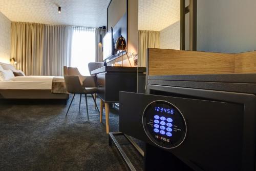a hotel room with a bed and a tv in a room at Vienna House Easy by Wyndham Dortmund City in Dortmund