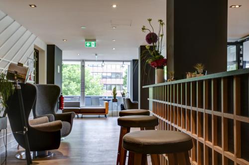 a barber shop with stools and a waiting room at Vienna House Easy by Wyndham Dortmund City in Dortmund