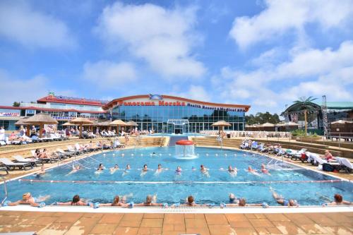 a large pool with people swimming in it at Aquapark Health Resort & Medical SPA Panorama Morska All Inclusive in Jarosławiec