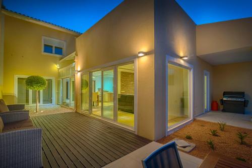 Ein Haus mit einer großen Terrasse mit Glastüren in der Unterkunft villa Aqua-Jacuzzi-heatable pool-sauna-gym-snooker in Albufeira