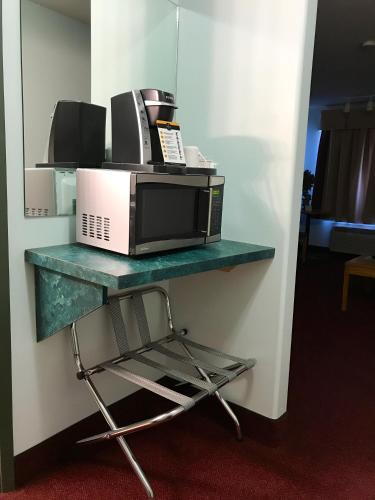 a microwave on a shelf with a chair on it at Super 8 by Wyndham Kindersley in Kindersley