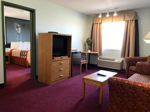 a hotel room with a bed and a television at Super 8 by Wyndham Kindersley in Kindersley