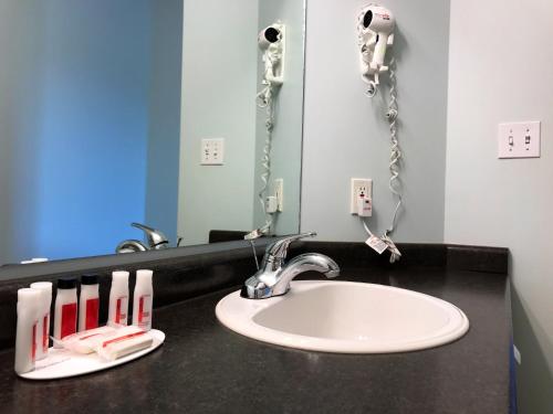 a bathroom with a sink and a mirror at Super 8 by Wyndham Kindersley in Kindersley