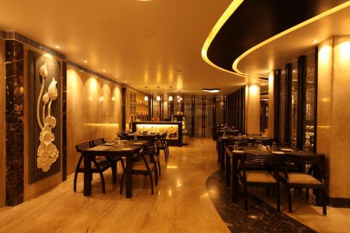 a restaurant with tables and chairs in a room at Hotel Southern Residency- near to SIPCOT in Kelambākkam