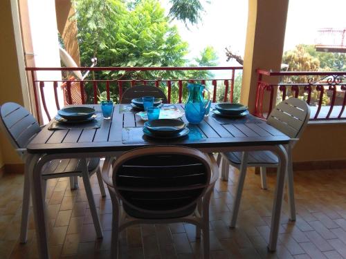 un tavolo di legno con sedie e bicchieri blu sopra di Poggio del Sole a Letoianni