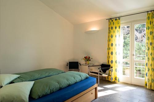 a bedroom with a bed and a desk and a window at Podere Riparbella in Massa Marittima