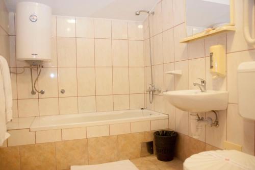 La salle de bains est pourvue d'un lavabo, d'une baignoire et de toilettes. dans l'établissement Taxi Bar Motel, à Gradiška