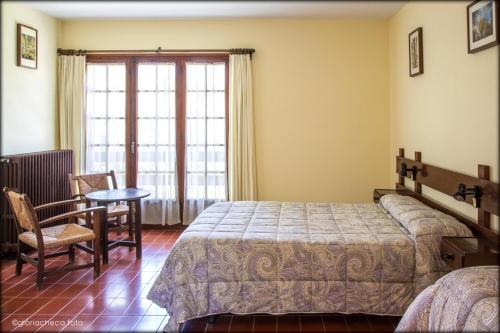 a bedroom with a bed and a table and a chair at Hostal l'Avet Blau in Santa Fe de Montseny