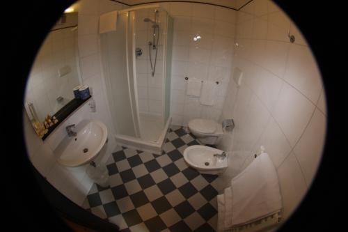 a bathroom with two sinks and a shower and two toilets at Antica Locanda Il Sole in Castel Maggiore