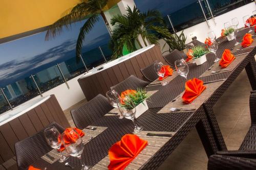 a table with orange napkins and glasses on a balcony at Hotel Titanium Plaza in Barrancabermeja