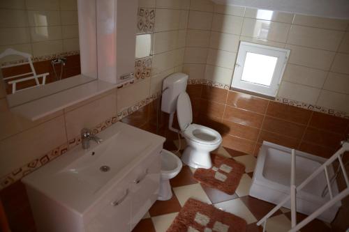 a bathroom with a toilet and a sink and a window at Hostel Tuba in Pristina