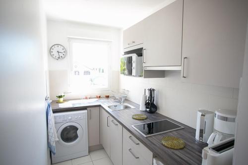 Mainvilliers的住宿－Grain de Blé，白色的厨房配有洗衣机和水槽