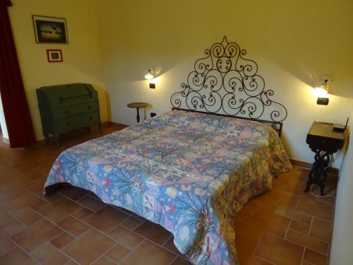 a bedroom with a bed with a floral bedspread at La Fattoria al Crocefisso in Pieve Fosciana