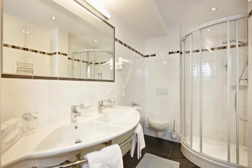 a white bathroom with a sink and a toilet at Villa Sonne Gerlos - only room in Gerlos