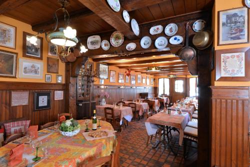 a restaurant with tables and chairs and plates on the wall at Hotel Restaurant Dontenville in Châtenois