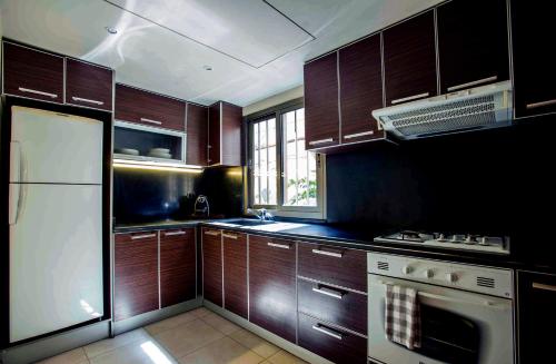 a kitchen with wooden cabinets and a white refrigerator at Lahoya Beirut in Beirut