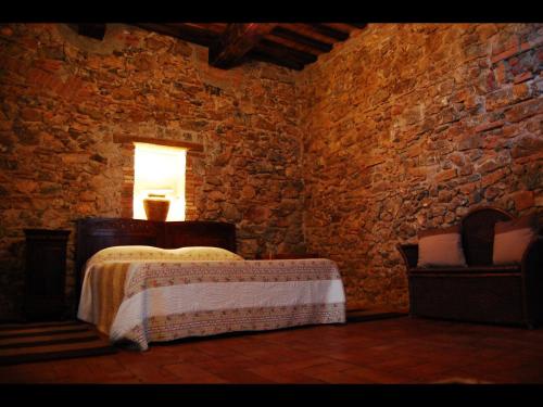 una camera con un letto in una parete in pietra di Agriturismo Bio Fattoria di Pietra a Giuncarico
