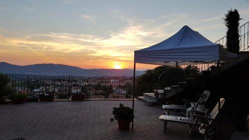 a white tent on a patio with the sunset in the background at Villa Lucrezia in Reggello