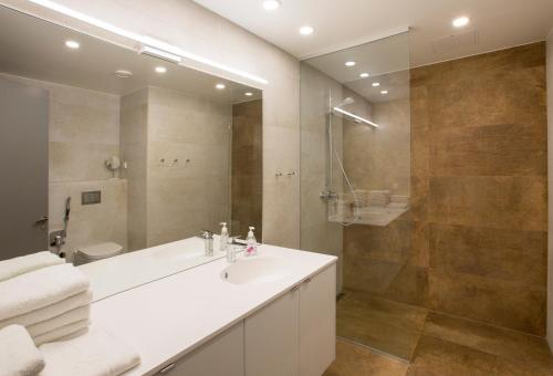 ein Badezimmer mit einem weißen Waschbecken und einer Dusche in der Unterkunft Korter Villa 1 in Pärnu