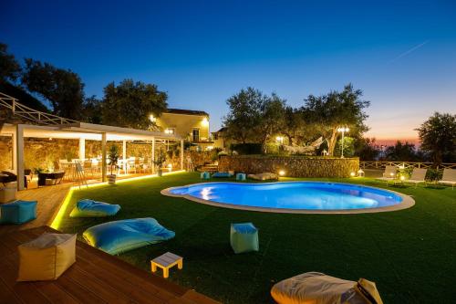 a backyard with a swimming pool at night at MelRose Relais in Massa Lubrense