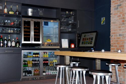 a bar with bar stools and a counter with drinks at ibis Styles Roanne Centre Gare in Roanne