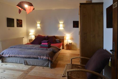 a bedroom with a bed and two chairs in it at Le chalet de Valentine in Ventron