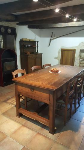 a wooden table with a pizza on top of it at Gite de Souilhol in Issendolus