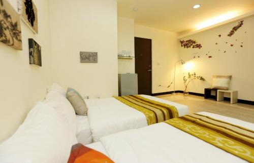 a hotel room with two beds and a couch at Mei Lodge in Taipei