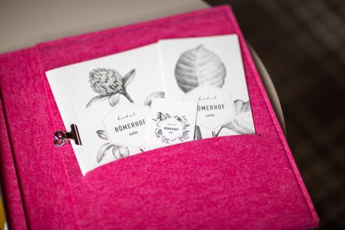 a pink album with a picture of flowers on it at Hotel Garni Römerhof in Innsbruck