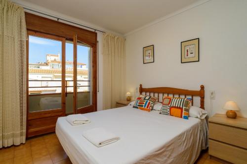 a bedroom with a bed and a large window at Costabravaforrent Masferrer in L'Escala