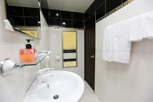 baño blanco con lavabo blanco y bañera en Mei Lodge, en Taipéi