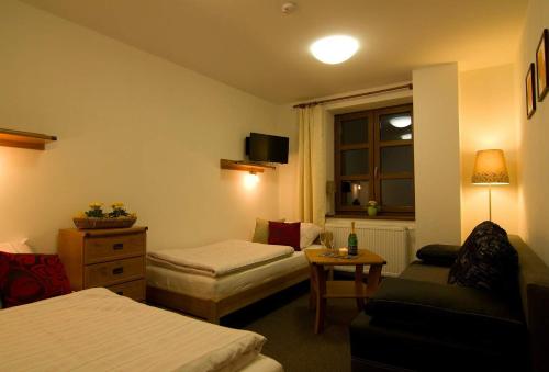 ein Hotelzimmer mit einem Bett und einem Sofa in der Unterkunft Ubytovací hostinec Na Skalách in Budislav