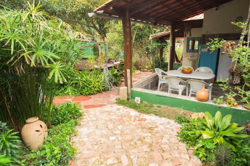 a garden with a patio with a table and chairs at Vyzuh in Vale do Capao
