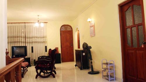 a living room with a door and a television at Anura Home Stay in Kalutara