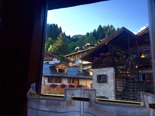 a view from a window of a building with flowers at La Tana dell'Orso in Forni di Sopra
