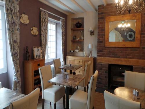 une salle à manger avec une table et des chaises et une cheminée dans l'établissement Le Montaigne, à Saint-Alvère